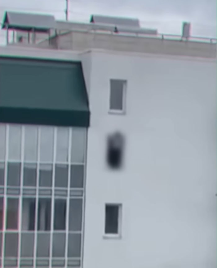 Blurred figure visible in a window of a tall building highlighting the horror of Dubai's infamous porta potty parties.