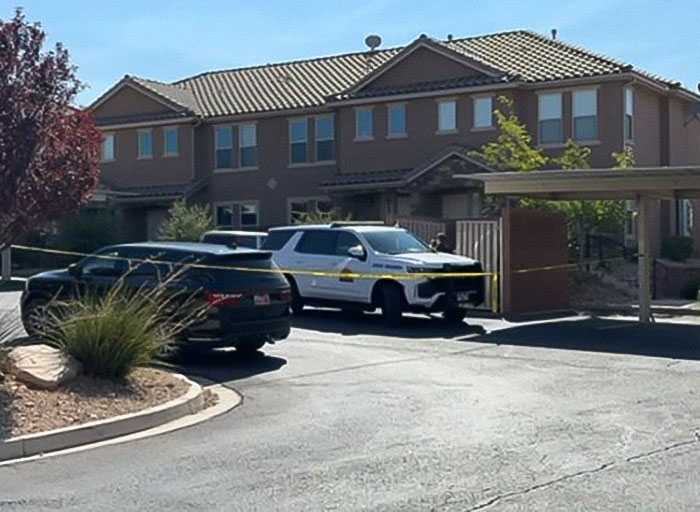 Police vehicle and yellow tape outside a residential complex during investigation into Tyler Robinson's trans partner disappearance. Police vehicle and yellow tape outside a residential complex during investigation into Tyler Robinson's trans partner disappearance.