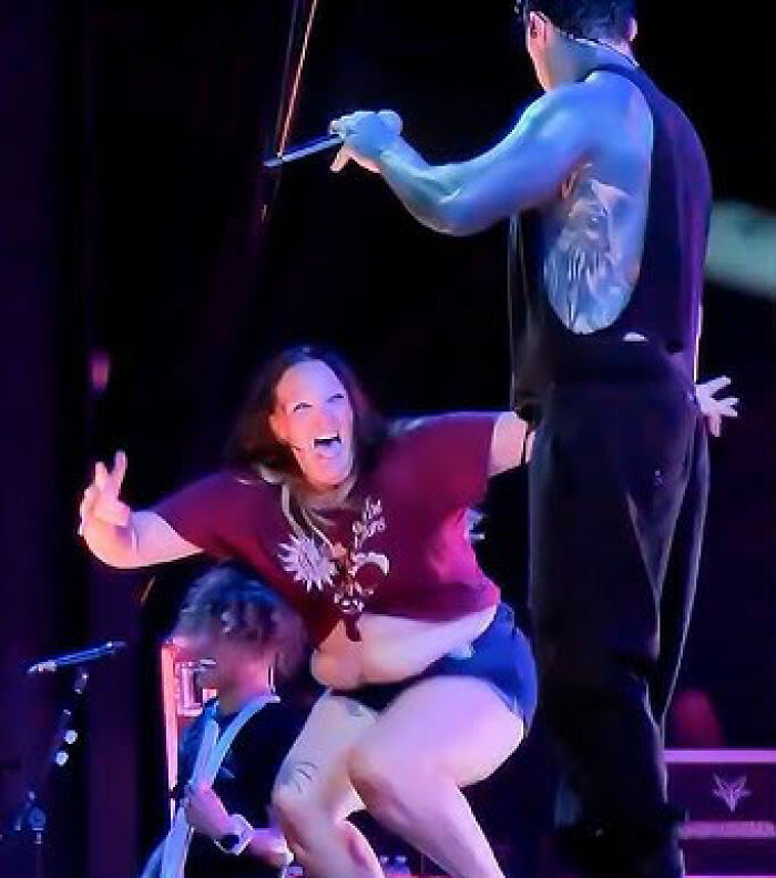 Ex-con rock star confronts woman who rushed the stage, sparking backlash over fat shaming during live concert performance.