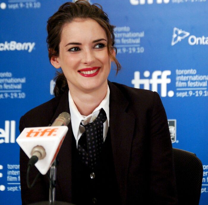 Smiling woman at a press conference discussing shocking and nasty things exes did that grossed out their partners.