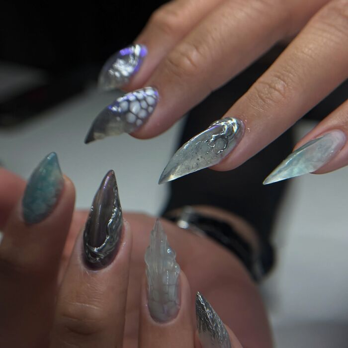 Unique nail designs with abstract patterns and textures on pointed nails showcasing creative nail art trends.