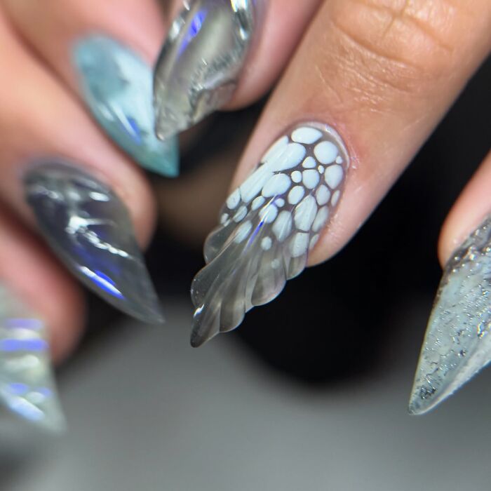 Unique nail designs with abstract patterns and textures on pointed nails showcasing creative nail art trends.