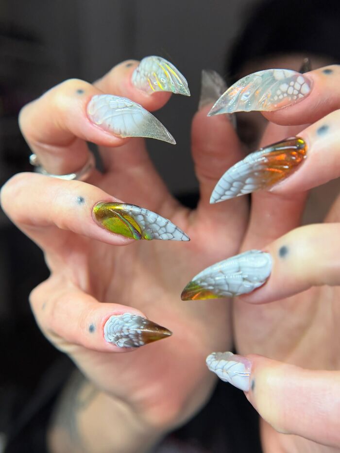 Unique nail designs with translucent butterfly wing patterns and unusual shapes creating an eye-catching look.