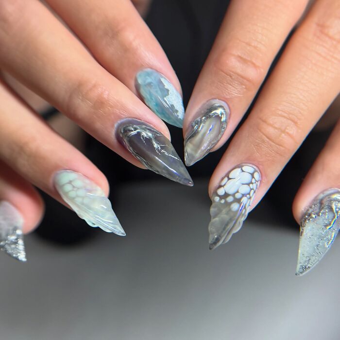 Unique nail designs with abstract patterns and textures on pointed nails showcasing creative nail art trends.