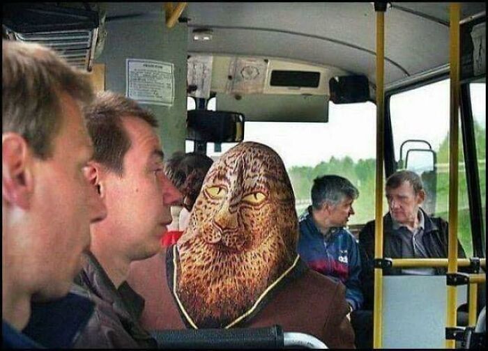 Passengers on a bus with one person wearing a leopard face mask, capturing quirky Eastern Europe memes and culture.