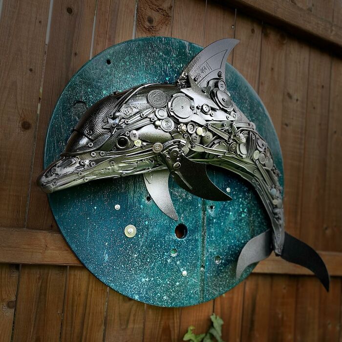 Metal dolphin sculpture made from trash and recycled items, showcasing stunning animal art with intricate details.
