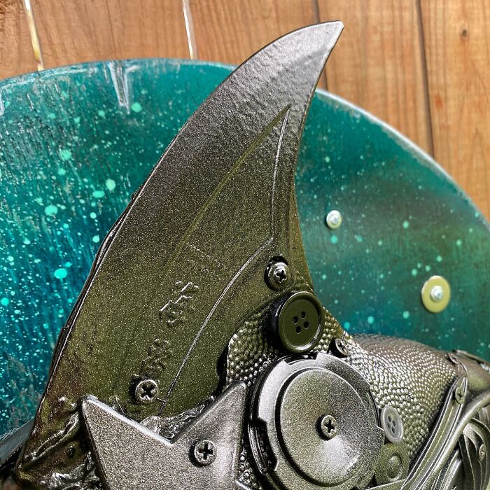 Metal dolphin sculpture made from trash and recycled items, showcasing stunning animal art with intricate details.