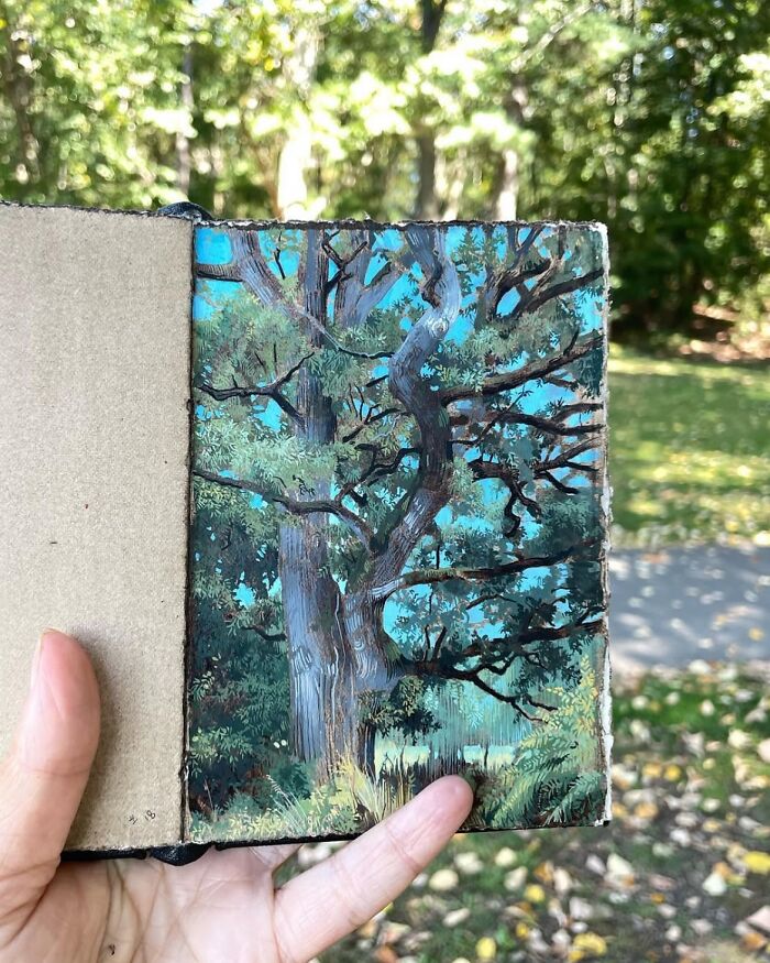 Hand holding a detailed painting of a tree by Dina Brodsky showcasing the beauty of the natural world.