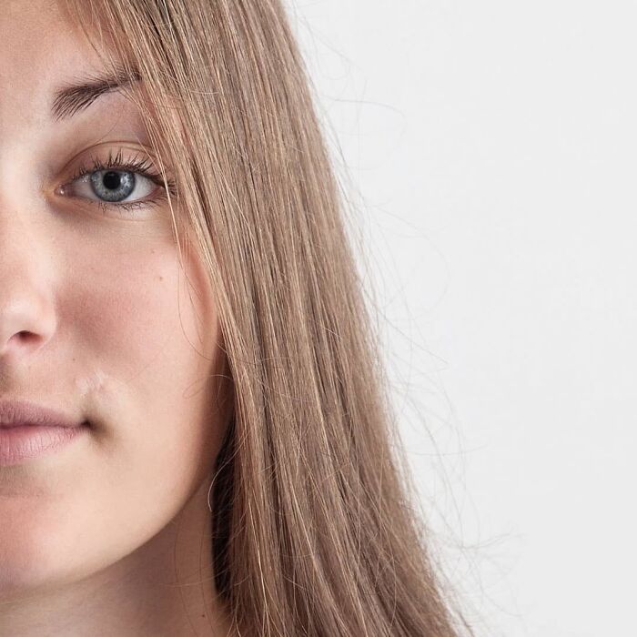 Young woman with long brown hair and blue eyes looking straight at the camera in a genetic portrait showing family DNA traits.
