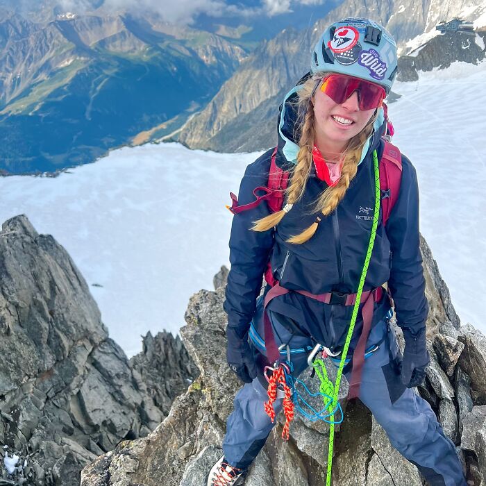 Teen climber on rocky mountain peak with climbing gear, highlighting risks of Everest climb and online debate about safety. Teen climber on rocky mountain peak with climbing gear, highlighting risks of Everest climb and online debate about safety.