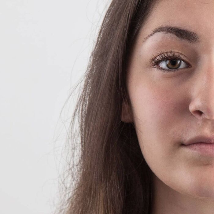 Young woman with long brown hair and blue eyes looking straight at the camera in a genetic portrait showing family DNA traits.
