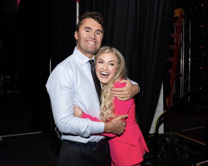 Two people smiling and hugging backstage, illustrating public reaction to FBI Director under fire in Charlie Kirk case.