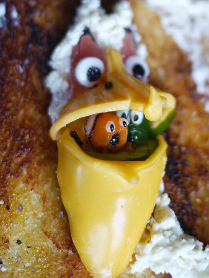 Creative meal by a Japanese mom featuring toast decorated with cheese and vegetables, served with a cup of black coffee.