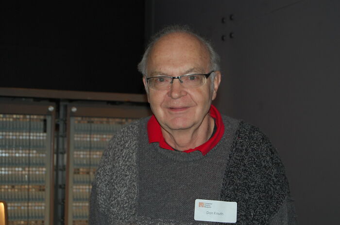 Elderly man wearing glasses and a sweater, representing bold decisions that made a massive impact worldwide.