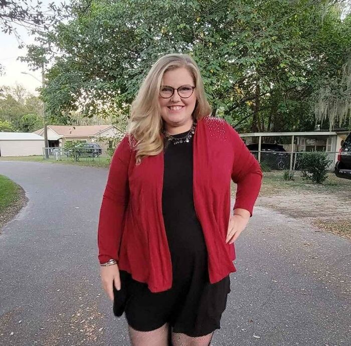Woman smiling outdoors wearing red cardigan and black dress, related to mom of five missing again after being found in woods. Woman smiling outdoors wearing red cardigan and black dress, related to mom of five missing again after being found in woods.