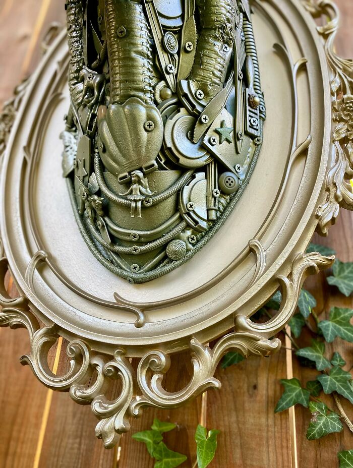 Recycled metal pieces crafted into a stunning animal sculpture mounted on a wooden fence outdoors.