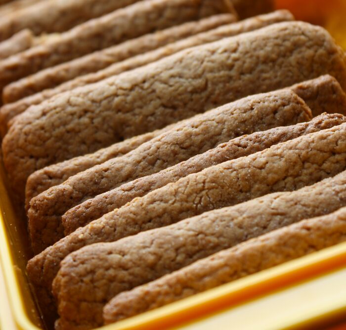 Close-up of textured biscuits neatly arranged in a yellow tray, illustrating real-life stories of transformation and change.