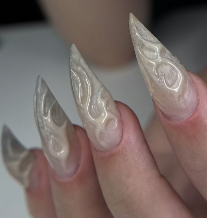 Long stiletto nail designs with translucent flame patterns creating a bold and unique nail art look.
