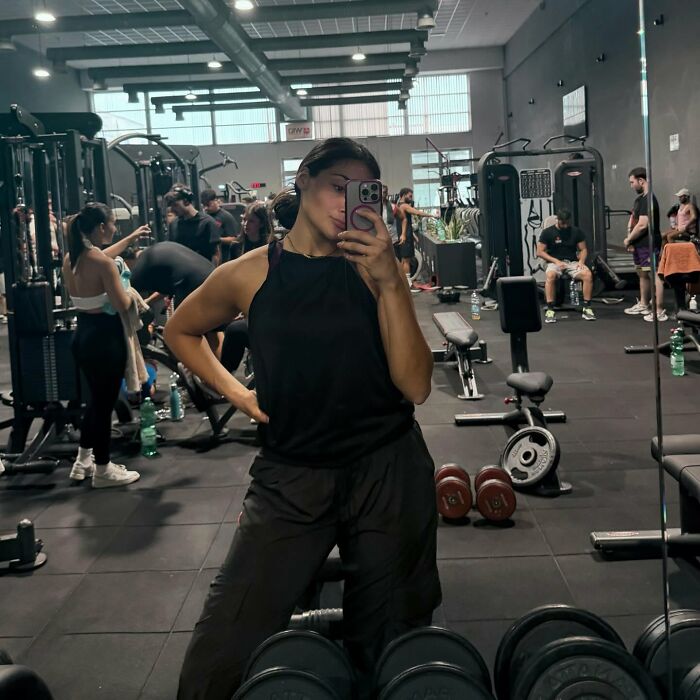 Female boxer taking a gym mirror selfie in workout clothes, highlighting boxer who refused to fight Imane Khelif.