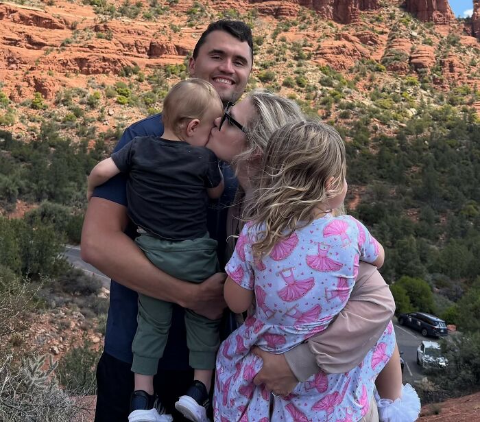 Family outdoors with children in a rocky desert setting, sparking heated debate over Erika Kirk and the feminist movement.