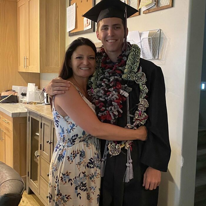 Young man in graduation gown and cap, smiling and hugging a woman in a floral dress at home, Charlie Kirk suspect context.