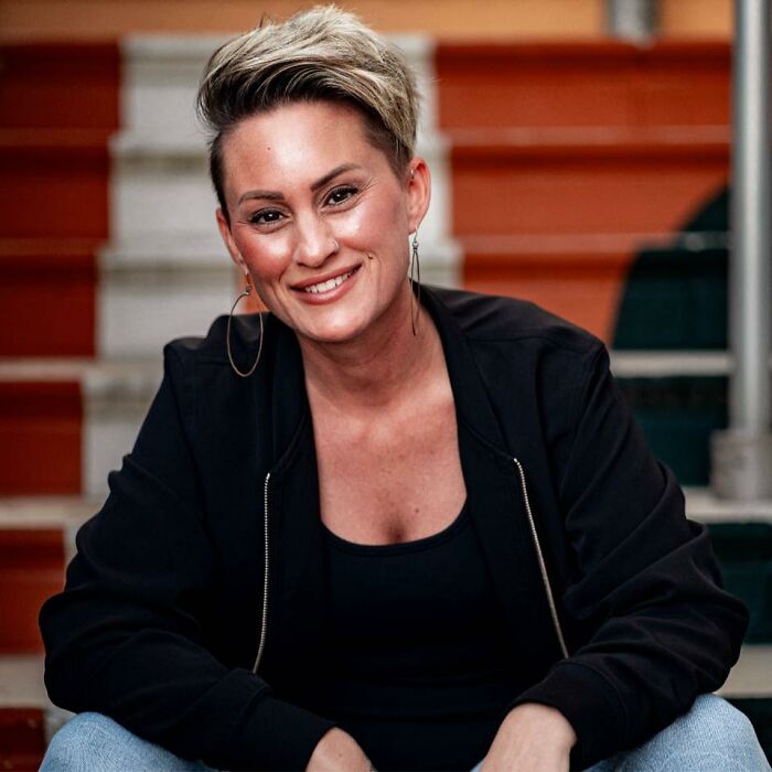 Smiling woman with short hair wearing a black jacket, representing a woman who orders Charlie Kirk's favorite Starbucks drink.