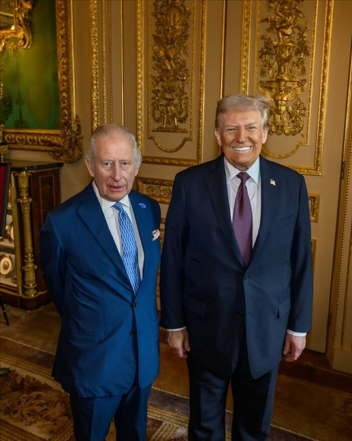 King Charles and Donald Trump standing together in a formal room, showing subtle signs of impatience during state visit.