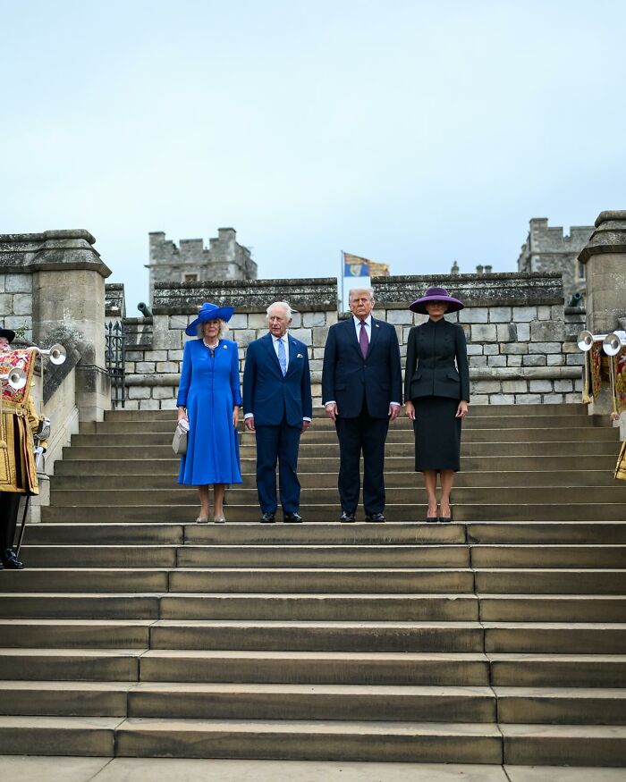 King Charles and Donald Trump standing with their spouses on castle steps during state visit showing subtle body language signs.