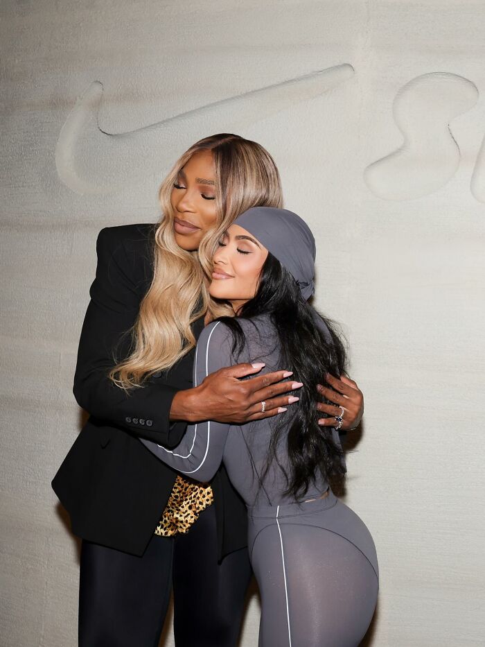 Serena Williams and a woman hugging, capturing a friendly moment amid heated reactions to NYC hotel cotton plant decoration. Serena Williams and a woman hugging, capturing a friendly moment amid heated reactions to NYC hotel cotton plant decoration.