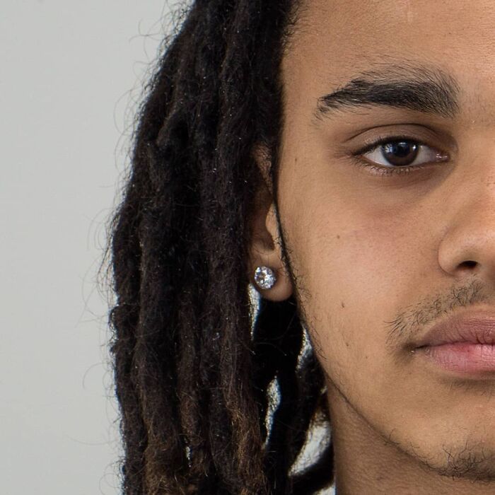 Close-up portrait of a young person with braided hair, illustrating diverse family DNA traits in a genetic portrait series.