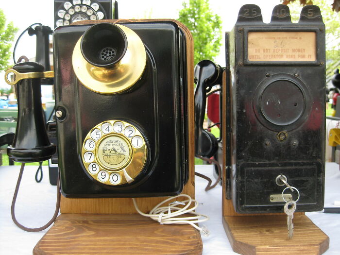 Vintage rotary wall phones displayed outdoors, illustrating bold decisions that made a massive impact on communication worldwide.