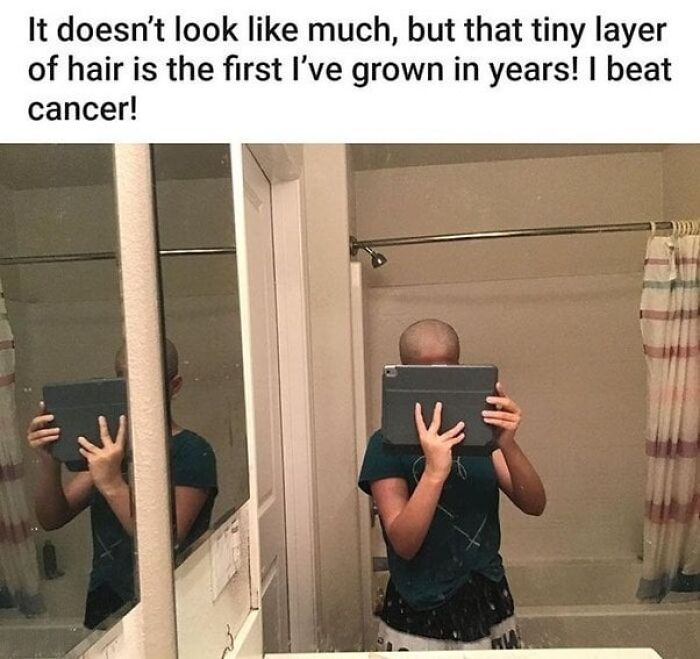 Person with shaved head taking a mirror selfie to show first hair growth after beating cancer, wholesome posts to inspire hope.