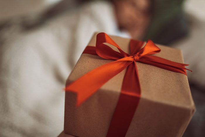 Gift box with a red ribbon, symbolizing unexpected things men didn’t know about women in dating relationships.