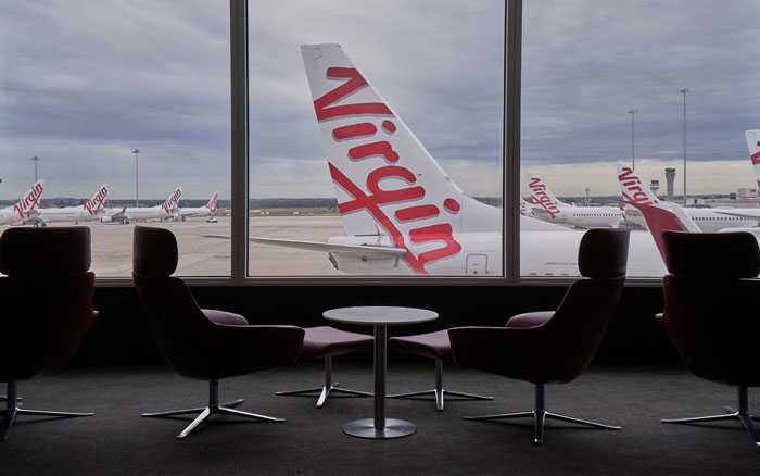 Airport lounge seating with Virgin Australia planes outside, related to doctor furious after being asked to leave lounge. Airport lounge seating with Virgin Australia planes outside, related to doctor furious after being asked to leave lounge.
