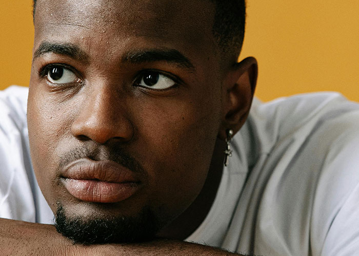 Close-up of a man looking away thoughtfully, illustrating the theme of men sharing creepy things women do that cross the line.