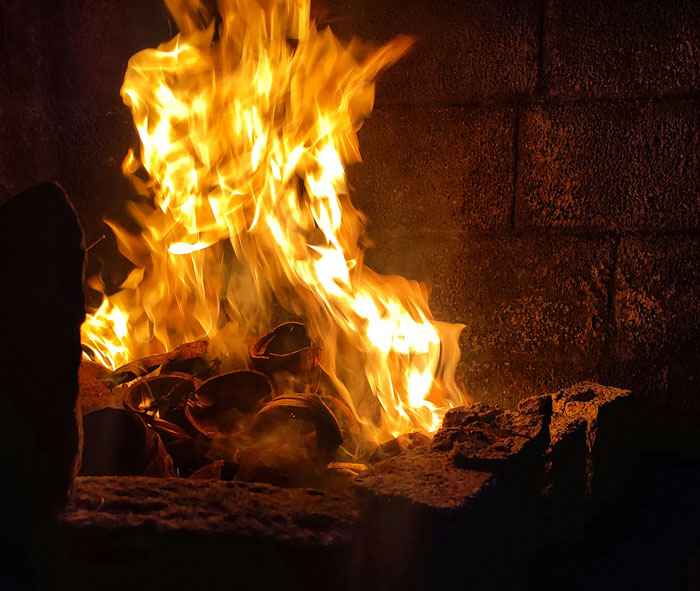 Flames burning intensely in a dark fireplace, evoking eerie and creepy feelings while home alone.