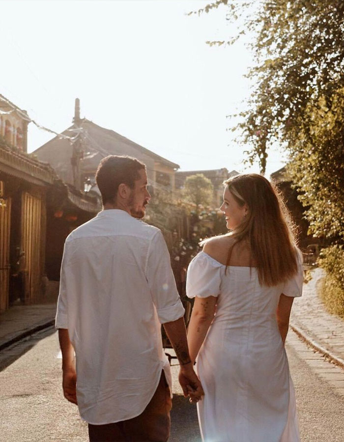 Newly engaged couple holding hands walking outdoors, linked to tragic poisoned limoncello incident as parents seek justice.