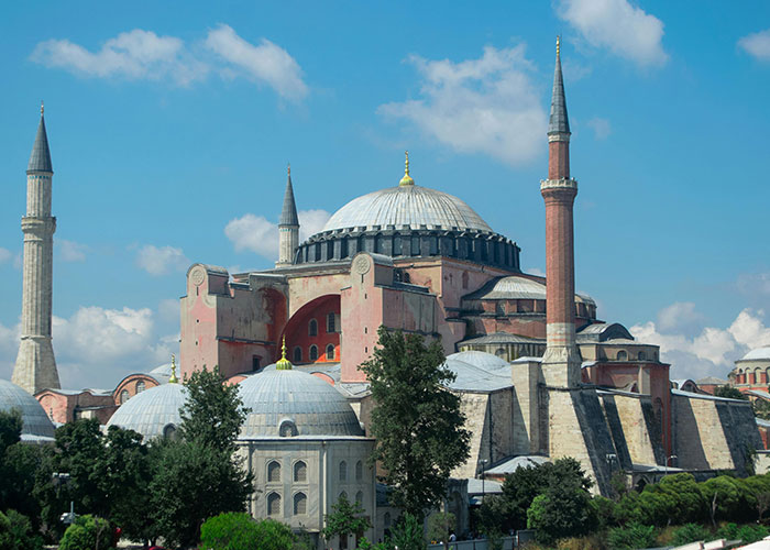Historic Hagia Sophia monument with domes and minarets, highlighting significant historical events with damage to society.