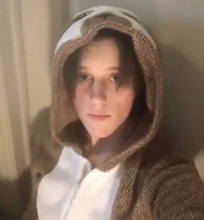 Young person wearing a hooded jacket indoors, related to Tyler Robinson's trans partner disappearance and neighbors speaking out. Young person wearing a hooded jacket indoors, related to Tyler Robinson's trans partner disappearance and neighbors speaking out.