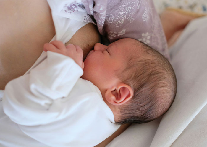 Newborn breastfeeding, highlighting health risks and stigma faced during pumping breast milk in public spaces.