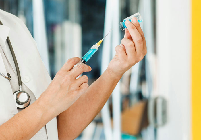 Medical professional preparing a syringe with vaccine, highlighting the complete collapse of common sense in healthcare settings.