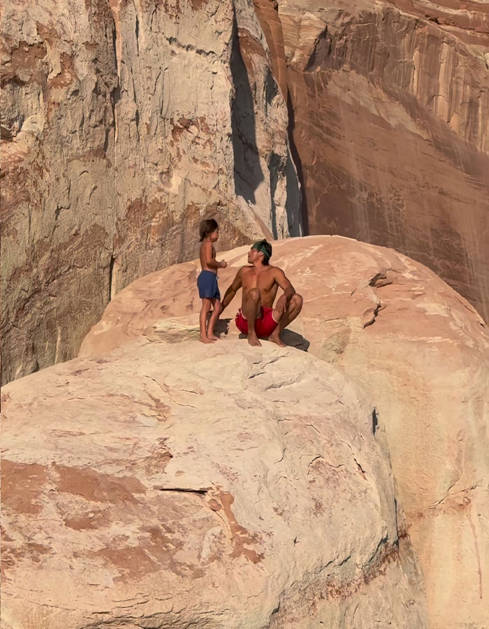 Dad and young son on rocky cliff, highlighting tough love and viral outrage around cliff incident. Dad and young son on rocky cliff, highlighting tough love and viral outrage around cliff incident.