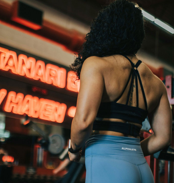 Woman in athletic wear at gym, highlighting strength and confidence relating to open marriage and relationship dynamics.