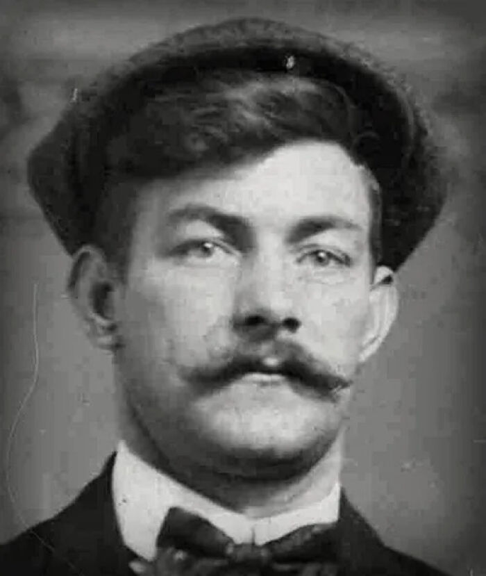 Black and white vintage portrait of a man with a mustache and hat related to famous fraud cases.