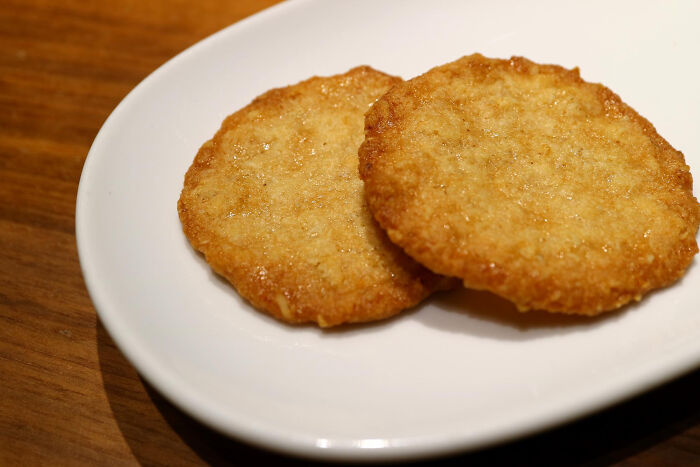 Two golden-brown crispy hash browns on a white plate, illustrating an absurd dealbreaker concept.