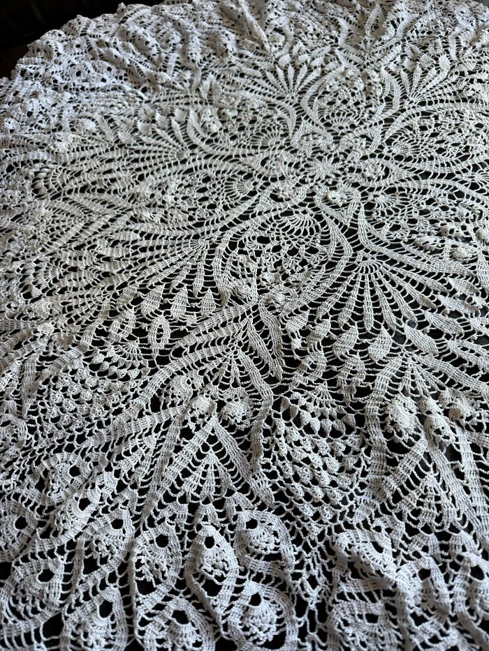 Intricate crocheted lace with detailed floral and geometric patterns showcasing expert crocheting craftsmanship.