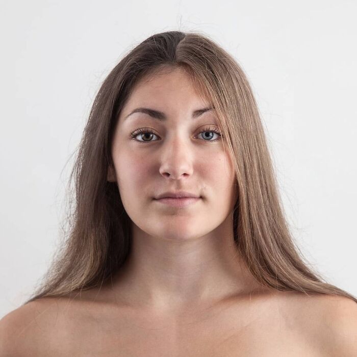 Young woman with long brown hair and blue eyes looking straight at the camera in a genetic portrait showing family DNA traits.