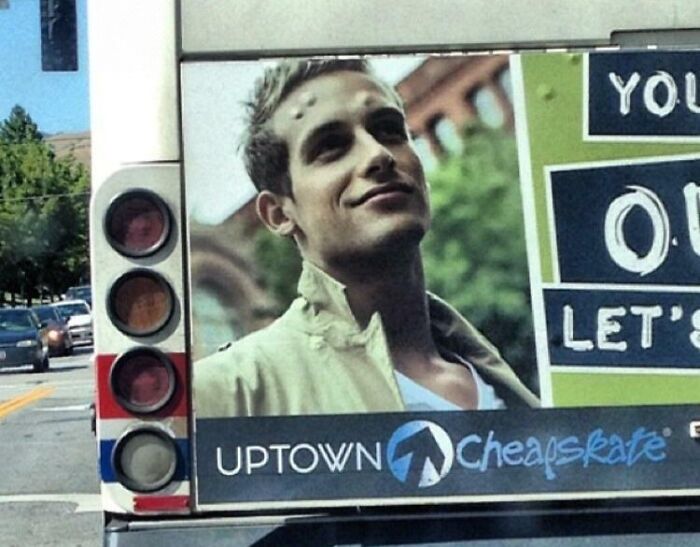 Bus advertisement with a young man smiling next to a sign showing an advertising placement fail.