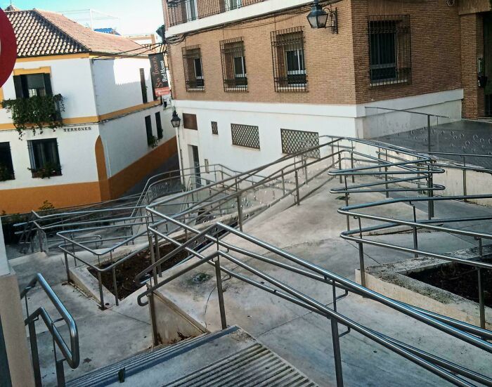 Confusing and poorly done wheelchair ramp with overlapping rails showing bad jobs by someone who just wanted to get it over with