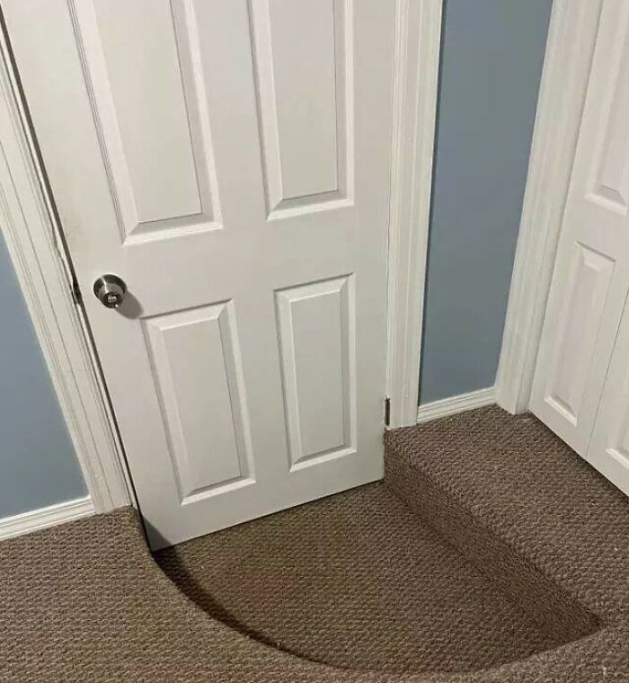Carpet installation done poorly with a curved cutaround a door, showing hilariously bad jobs done to just get it over with.